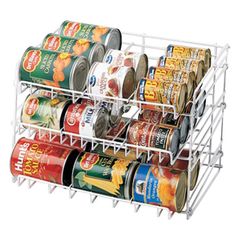 canned food is stored in a rack on the side of a white wall - mounted shelf