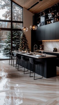 the kitchen is decorated for christmas with black cabinets and marble countertops, along with an island