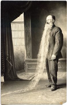 an old man with long white hair standing in front of a doorway and looking at something