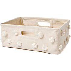 a white storage basket with pom - poms on the handles and bottom part