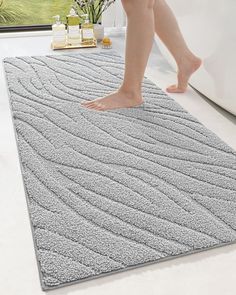 a person walking across a bathroom rug on the floor