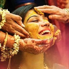 a woman is getting her face painted yellow