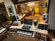 there are many electronic equipment on the table in this room, including keyboards and monitors