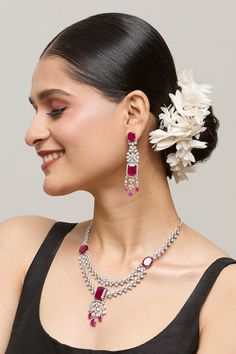 Silver plated double layer necklace embellished by white stone studded floral motifs highlighted by red ruby detail. Comes with matching earrings. - Aza Fashions Festive Ruby Jewelry With Elegant Design, Elegant Pink Ruby Jewelry Sets, Elegant Ruby Jewelry Sets In Pink, Elegant Ruby Jewelry Sets For Festive Occasions, Elegant Ruby Jewelry Sets For Festive Season, Elegant Ruby Bridal Necklace For Festive Occasion, Elegant Ruby Bridal Necklace For Festive Season, Elegant Ruby Earrings For Reception, Elegant Ruby Jewelry For Festive Occasions