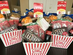 popcorn buckets filled with movie snacks on top of a table