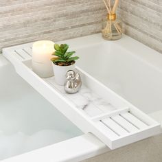 a white bath tub sitting next to a candle