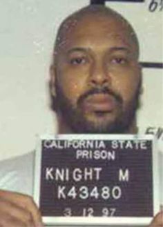 a man holding up a sign that says california state prison knight m k 43380