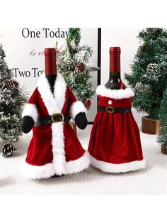 two wine bottles dressed as santa claus and holding hands in front of christmas tree decorations