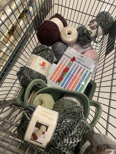 a shopping cart filled with yarn and crochet hooks, needles, and balls of yarn