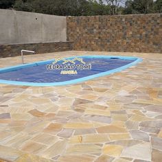 an empty swimming pool in the middle of a stone patio with a sign on it