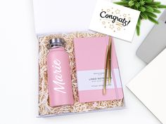 a pink personalized gift set in a box next to a laptop and cactus plant