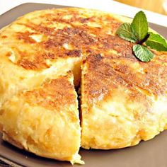 a pancake that has been cut in half and is sitting on a plate with a green leaf