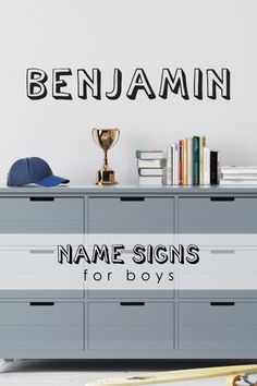 the name signs for boys are displayed on a wall above a dresser with books and other items