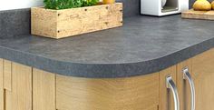 a kitchen counter top with a wooden box on it and some vegetables in the middle