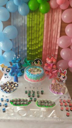 a table topped with a cake and lots of balloons