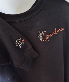 The cutest, simple yet heartfelt grandma sweatshirt embroidered just for you! Have the initial of each of her favorite little people embroidered on the sleeve of this cute grandma shirt. Personalized the way you need for your grandma to show your love! You can also choose to have "Nana", "Gigi", or any name she goes by embroidered instead.  perfect for Grandma for mother's Day, her birthday,or any day! Grandma is embroidered in a pretty script on the right shoulder with a pretty, dainty wildflow Long Sleeve Tops With Custom Embroidery As Gift, Custom Embroidered Long Sleeve Tops As Gift, Fall Tops With Embroidered Logo As Gift, Fall Tops With Embroidered Graphics For Gift, Embroidered Tops For Fall Gift Giving, Embroidered Tops For Fall Gifts, Embroidered Tops As Fall Gifts, Long Sleeve Tops With Embroidered Text For Gift, Floral Embroidery Crew Neck Top As Gift