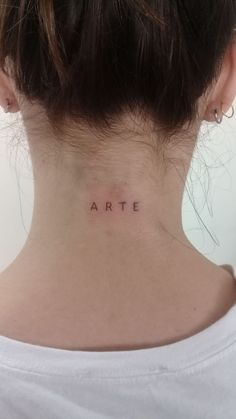 a woman's back neck with the word art on her left side ribcage