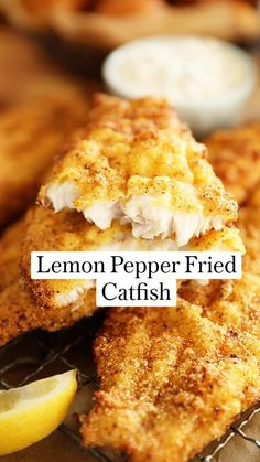 lemon pepper fried catfish on a cooling rack with lemon wedges next to it