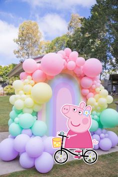 peppa pig on a bike in front of balloons