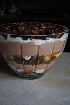 there is a dessert in the glass bowl on the table with chocolate and whipped cream