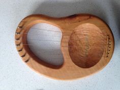 a small wooden instrument sitting on top of a white counter next to a pair of scissors