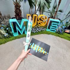 a person holding up a fake toothbrush in front of a sign that says museum