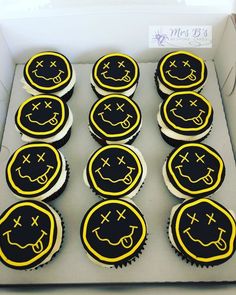 twelve cupcakes with smiley faces on them in a box