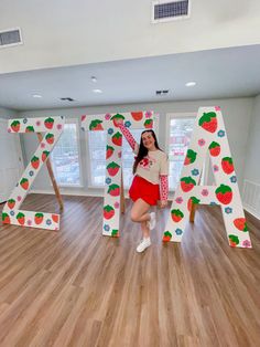 a woman posing in front of the letters that spell out strawberry's