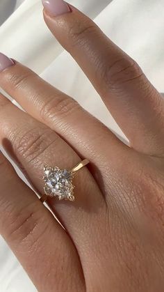 a woman's hand with a ring on it and a diamond in the middle