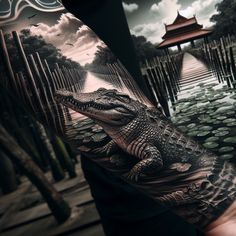 a man's arm with an alligator on it and water in the background,