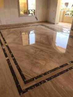 an empty room with marble flooring and mirrors on the wall, in front of two windows