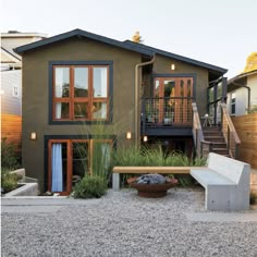 a house with some plants in the front yard and stairs leading up to it's second story