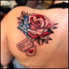 a woman's back with an american flag and a rose tattoo on her shoulder