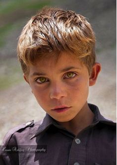 a young boy with blonde hair and green eyes