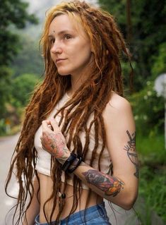 Embrace natural beauty with long, flowing dreadlocks paired with vibrant tattoo art. This look captures a serene outdoor moment, blending earthy vibes with colorful ink. Perfect for those who love to showcase their unique style and connection to nature. Fake Dreads, Embrace Natural Beauty, Course Hair, Hippie Movement, Hippie Culture