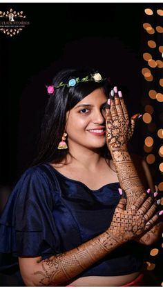 a woman holding her hands up with henna tattoos on it's arms and chest