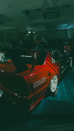 a red car parked in a garage next to other cars