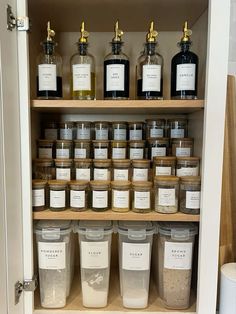 an open cabinet filled with lots of different types of jars and containers next to each other