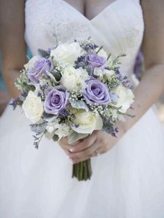 the bride is holding her purple and white bouquet