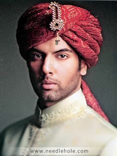 a man wearing a red turban and white shirt