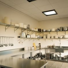 a kitchen filled with lots of pots and pans on top of metal shelving