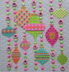 a cross stitch pattern with ornaments and beads on the bottom, in bright pinks and greens