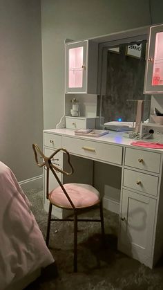 a chair sits in front of a desk with a mirror and lights on it,