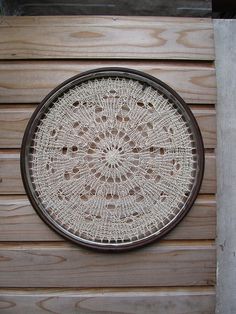 a white doily hanging on the side of a wooden wall