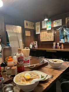 a man sitting at a table in front of bowls of food and condiments