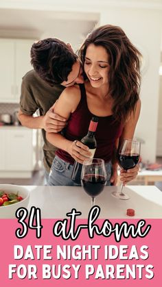 a man and woman kissing at the kitchen counter with wine glasses in front of them