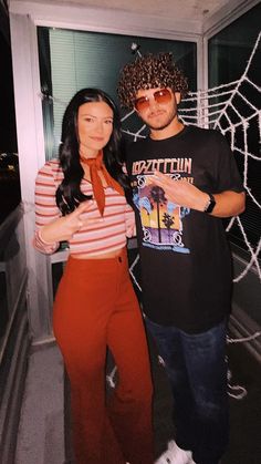 the man and woman are posing for a photo in front of a spider web net