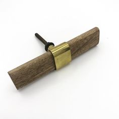 a wooden and brass object on a white surface with a black cord attached to it