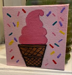 a pink ice cream cone with sprinkles painted on it's side