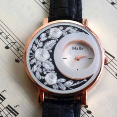 a close up of a wrist watch with music notes in the backgroung